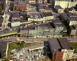 Birds eye view of colorful city buildings and a parking lot full of cars